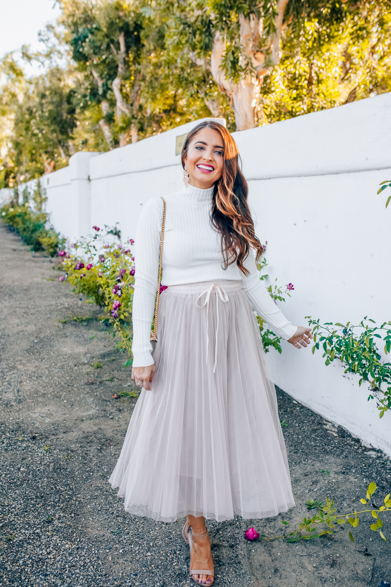 Tips to style a layered tulle skirt featured y top Los Angeles fashion blogger, Maxie Elise: image of a woman wearing a Chicwish long tulle skirt, Forever 21 cream turtleneck, Lisi Lerch earrings and Steve Madden sandals 