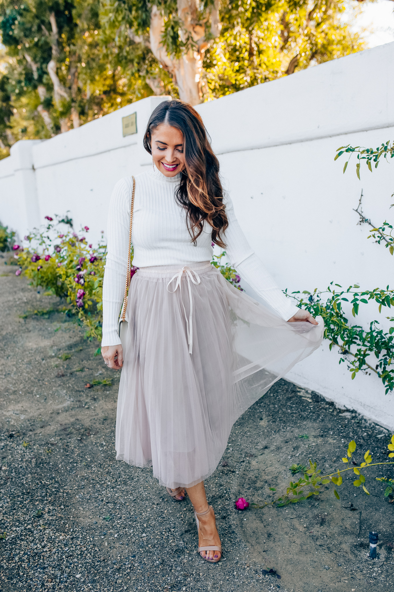 Tips to style a layered tulle skirt featured y top Los Angeles fashion blogger, Maxie Elise: image of a woman wearing a Chicwish long tulle skirt, Forever 21 cream turtleneck, Lisi Lerch earrings and Steve Madden sandals