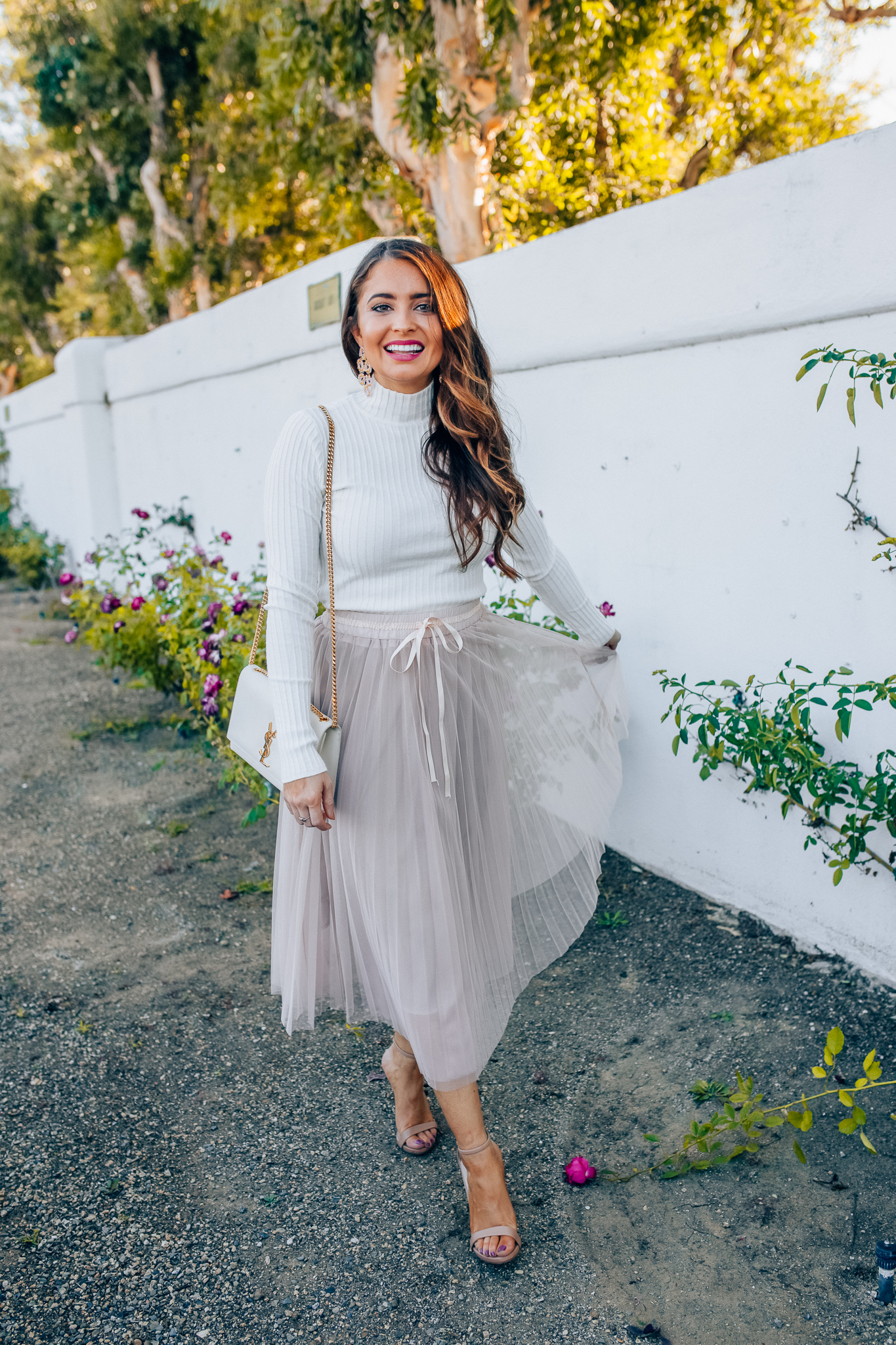 Tips to style a layered tulle skirt featured y top Los Angeles fashion blogger, Maxie Elise: image of a woman wearing a Chicwish long tulle skirt, Forever 21 cream turtleneck, Lisi Lerch earrings and Steve Madden sandals 