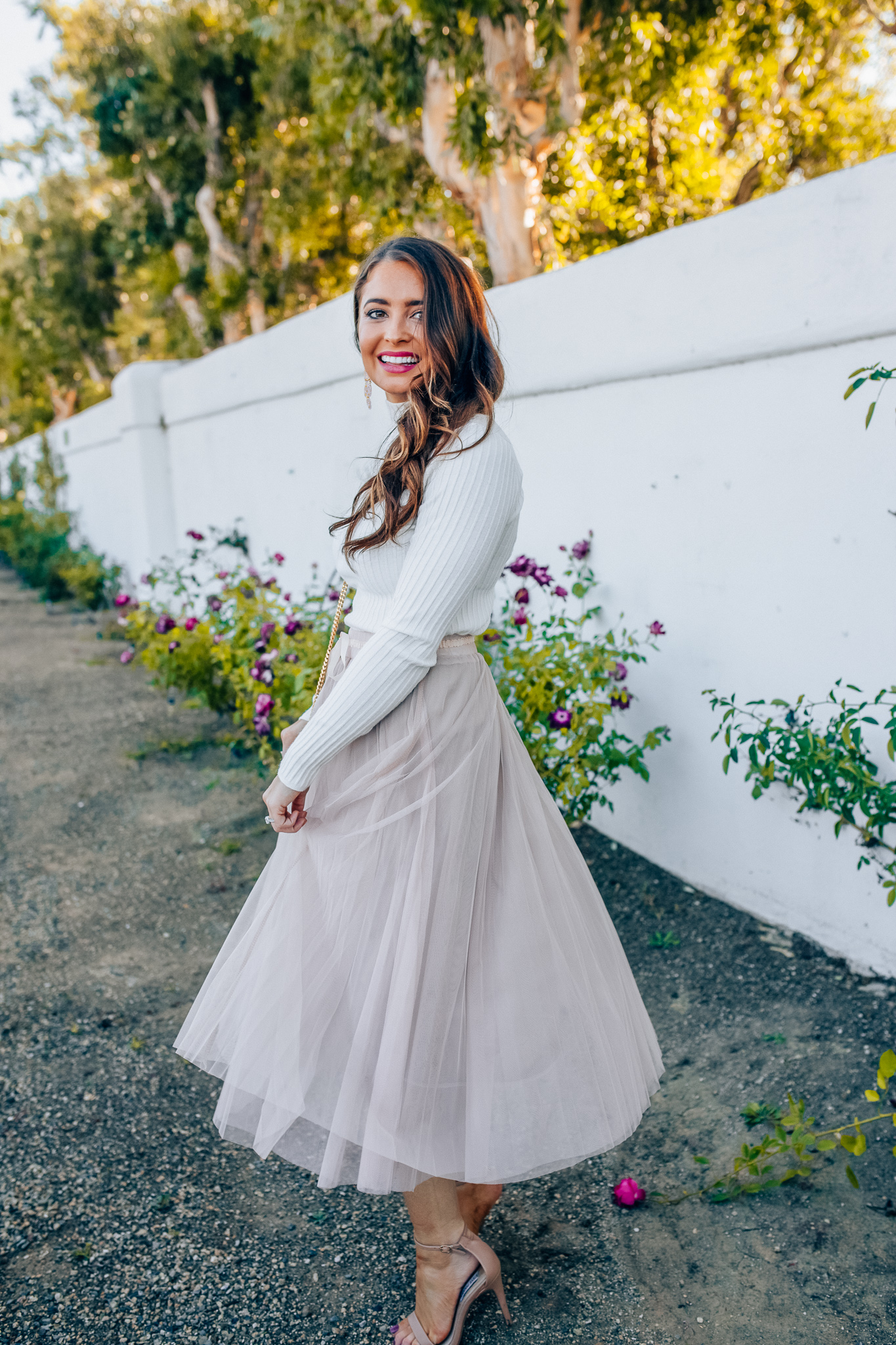 Tips to style a layered tulle skirt featured y top Los Angeles fashion blogger, Maxie Elise: image of a woman wearing a Chicwish long tulle skirt, Forever 21 cream turtleneck, Lisi Lerch earrings and Steve Madden sandals 