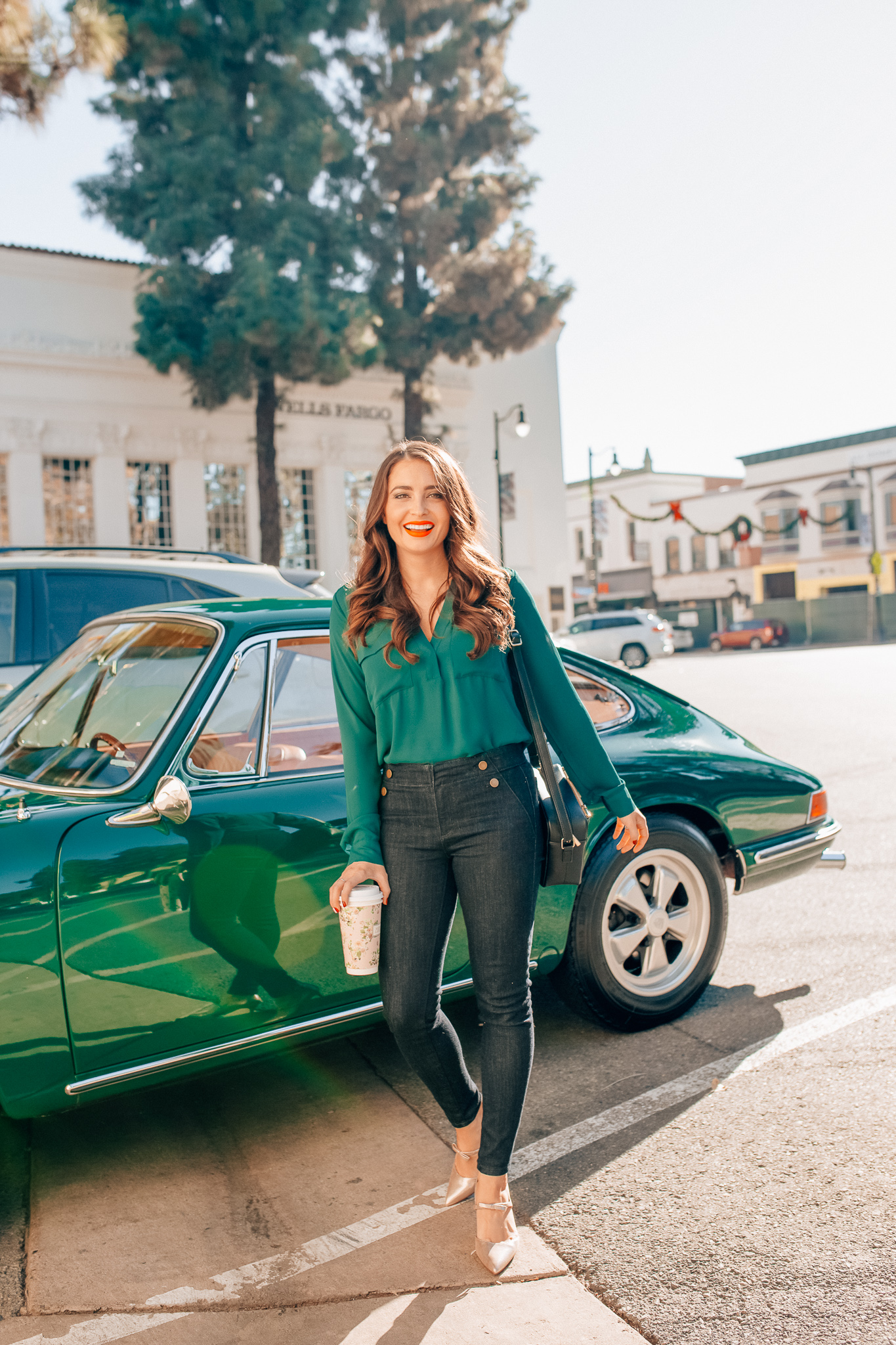 Winter workwear featured by top Orange County fashion blogger, Maxie Elise: image of a woman wearing an Ann Taylor green slim shirt, Ann Taylor skinny jeans, Ann Taylor metallic leather pumps and Ann Taylor camera bag
