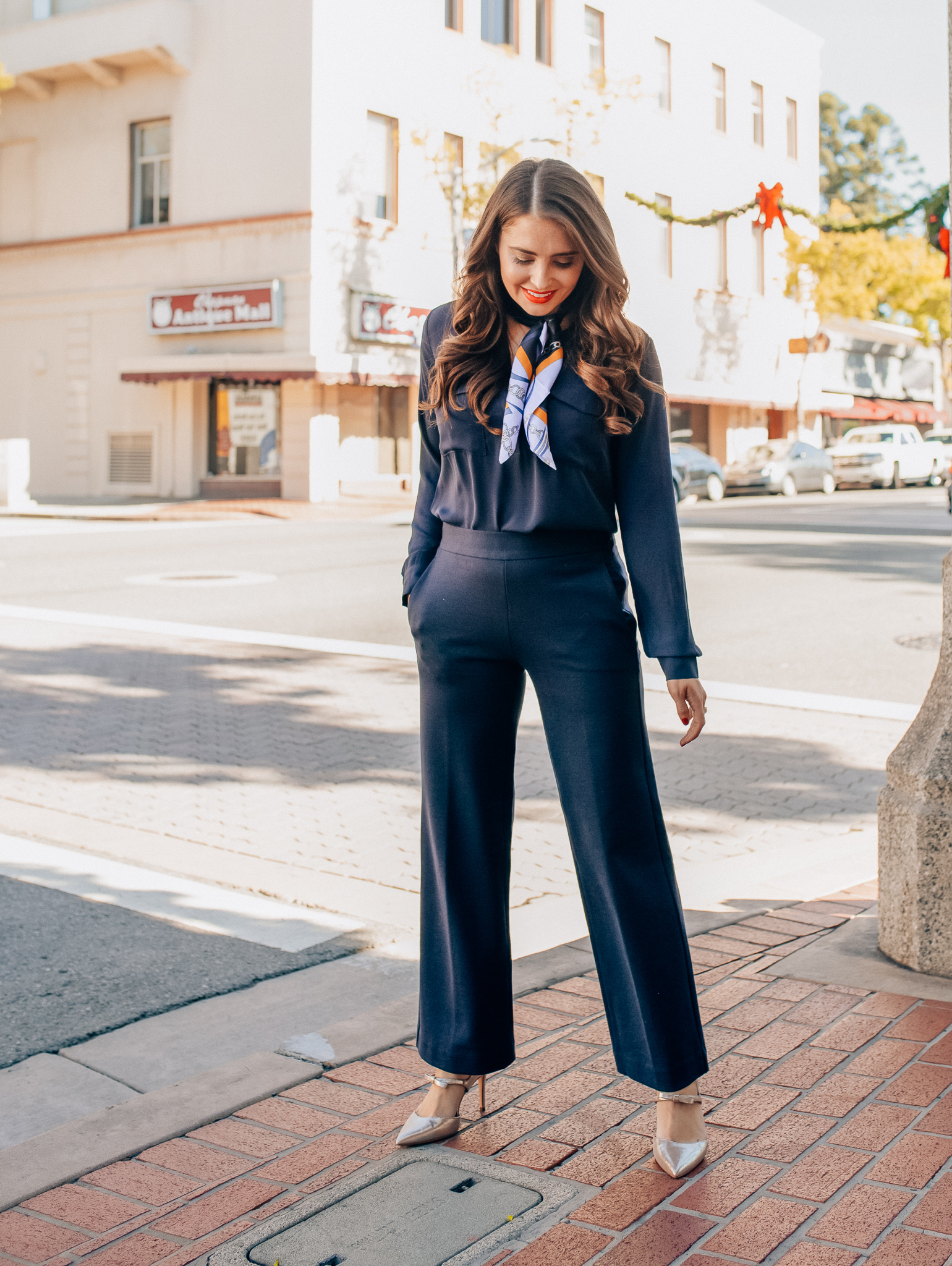 Winter workwear featured by top Orange County fashion blogger, Maxie Elise: image of a woman wearing an Ann Taylor blue slim shirt, Ann Taylor wide leg pants, Ann Taylor silk scarf, Ann Taylor metallic leather pumps and Ann Taylor camera bag