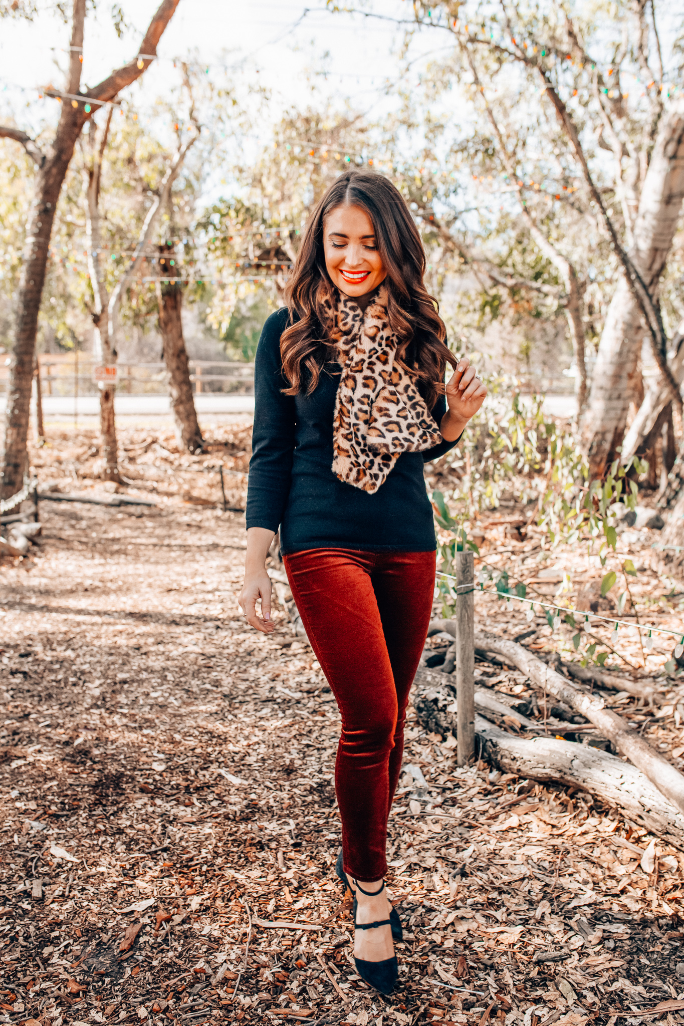 Leopard Holiday style featured by top Orange County fashion blogger, Maxie Elle: image of a woman wearing an Ann Taylor 3/4 sleeve black sweater, Ann Taylor faux fur stole, Ann Taylor red velvet pants, and Ann Taylor suede bow pumps